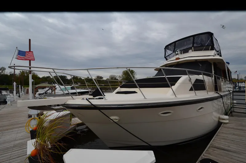 Slide: The Image of 1990 Jefferson 52 Marquessa ED yacht docked at marina with American flag. - 3