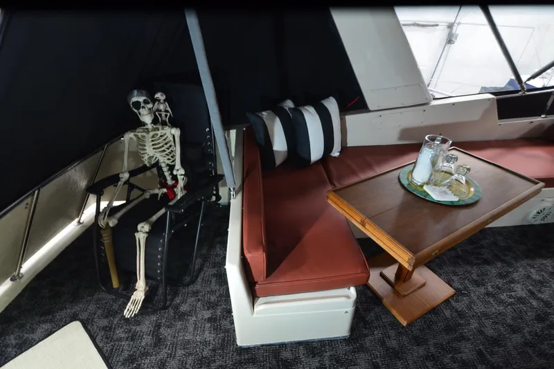 Slide: The Image of Skeleton seated on a 1990 Jefferson 52 Marquessa ED yacht with table setting. - 49