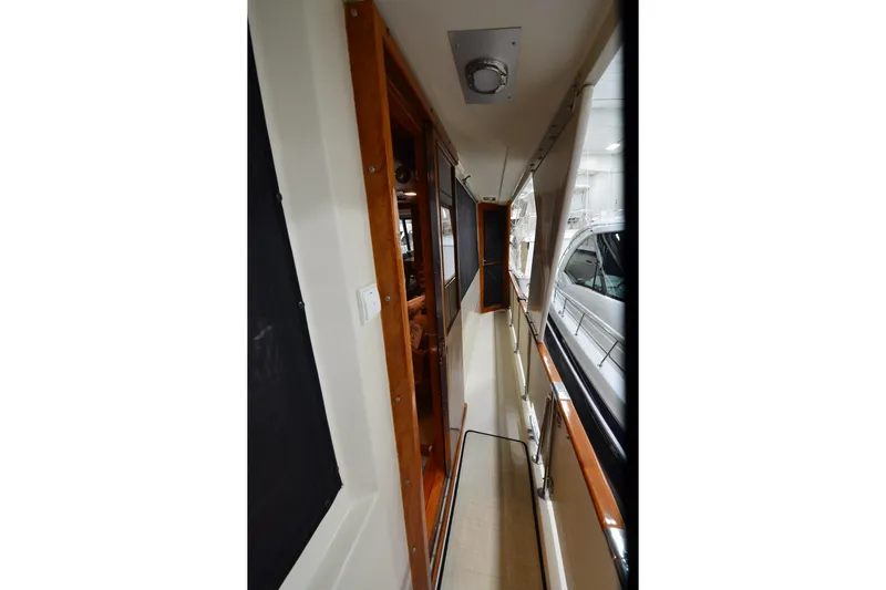 Slide: The Image of Narrow corridor on 1990 Jefferson 52 Marquessa ED yacht with wooden accents and windows. - 66