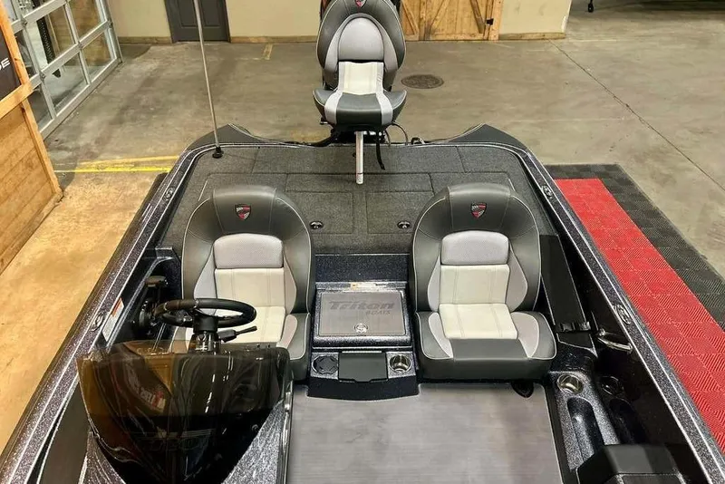 Slide: The Image of 2026 Triton 18 TrX boat interior with dual seats and steering wheel in showroom. - 10