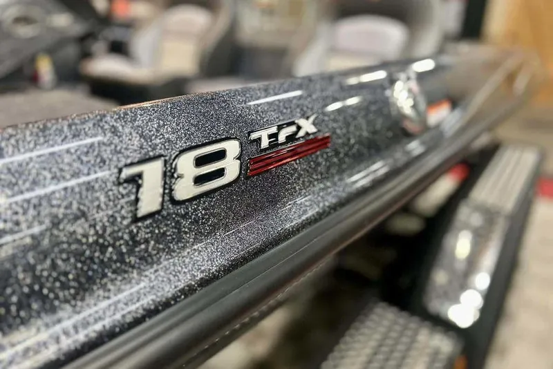 Slide: The Image of Close-up of 2026 Triton 18 TrX boat model emblem with metallic finish. - 16