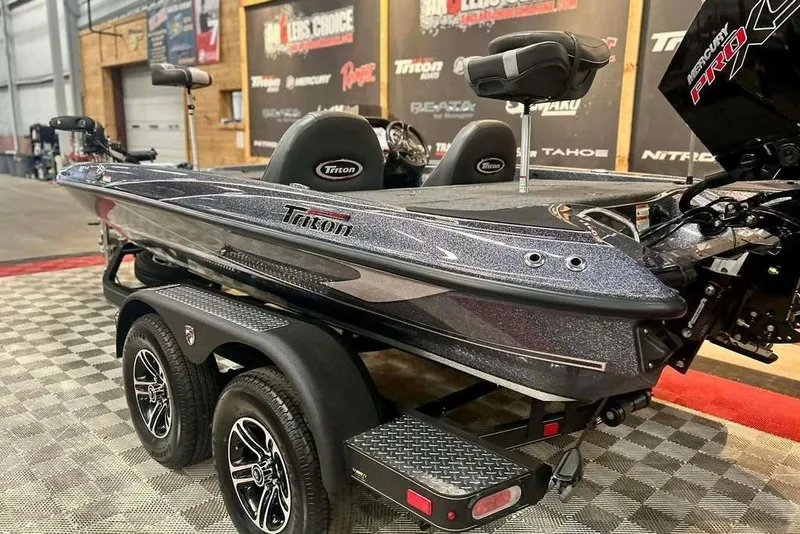 Slide: The Image of 2026 Triton 18 TrX bass boat on trailer, showcased indoors with sleek design. - 17