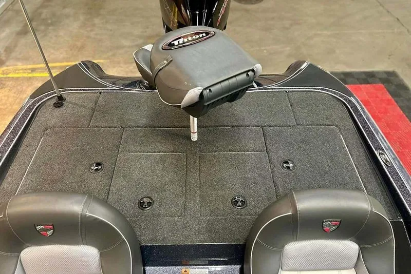 Slide: The Image of 2026 Triton 18 TrX boat interior with cushioned seats and storage compartments. - 18