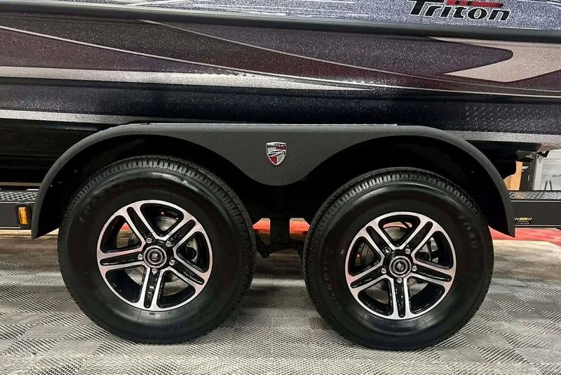 Slide: The Image of 2026 Triton 18 TrX boat trailer with dual black alloy wheels. - 19