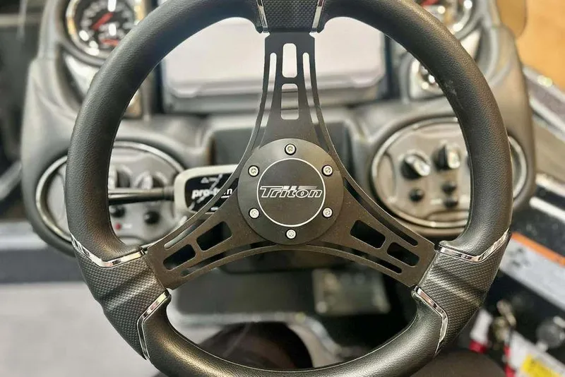 Slide: The Image of Steering wheel of 2026 Triton 18 TrX boat, featuring sleek design and controls. - 6