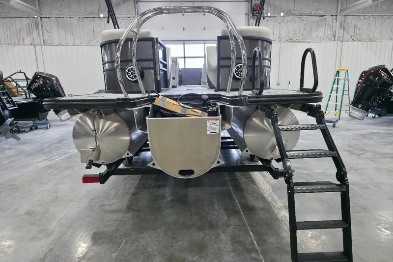 Slide: The Image of 2026 Sylvan Mirage X5 pontoon boat in a warehouse, rear view with ladder. - 3