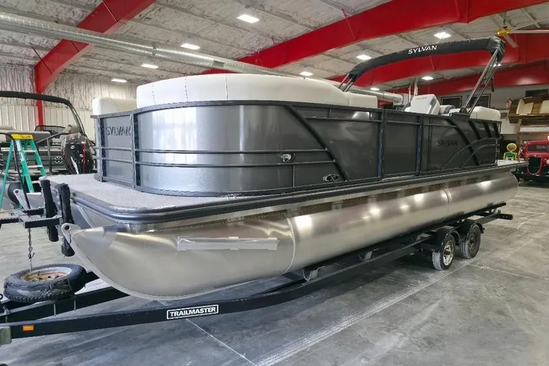 Slide: The Image of 2026 Sylvan Mirage X5 pontoon boat on trailer in indoor showroom. - 5
