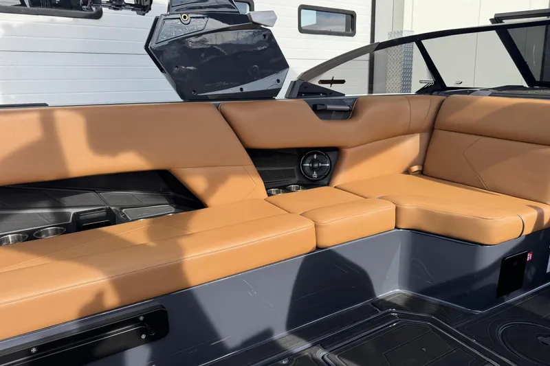 Slide: The Image of 2026 Moomba Tykon boat interior with tan leather seating and built-in speaker. - 10