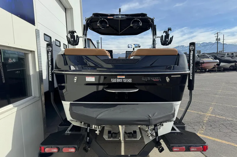 Slide: The Image of 2026 Moomba Tykon boat rear view, parked outside, showcasing sleek design and features. - 2