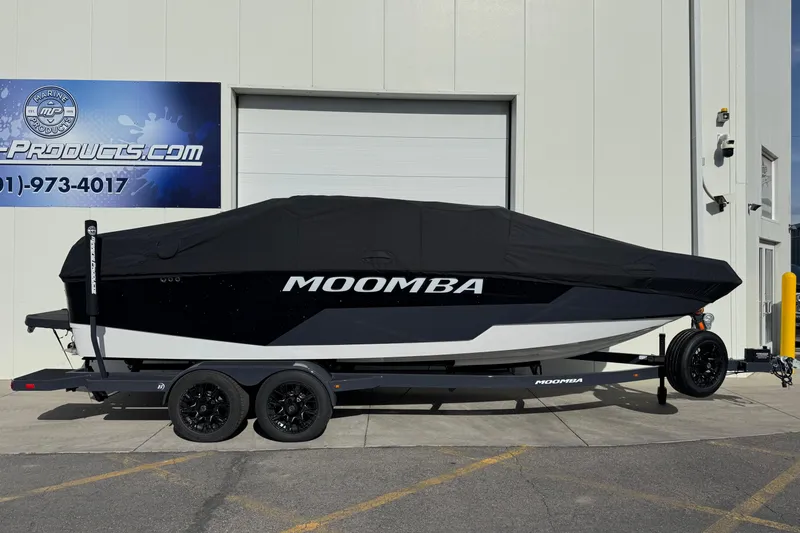 Slide: The Image of 2026 Moomba Tykon boat with cover on trailer, parked outside a building. - 5