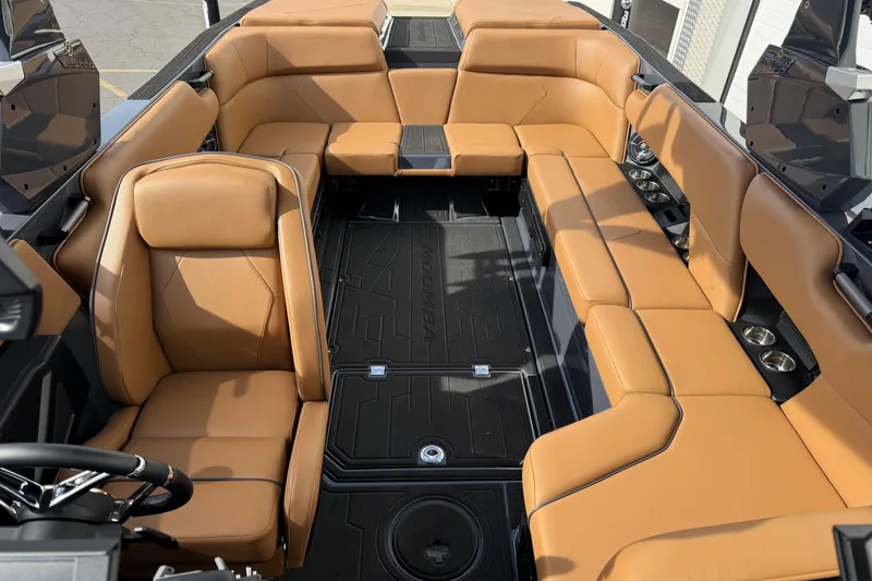 Slide: The Image of 2026 Moomba Tykon boat interior with tan leather seating and sleek black flooring. - 6