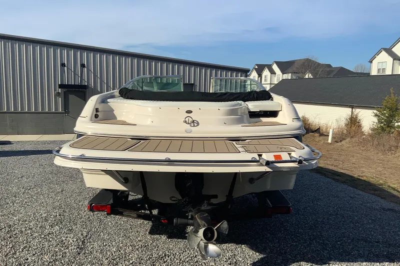 Slide: The Image of 2007 Bryant 206 boat rear view, parked on gravel near buildings. - 3