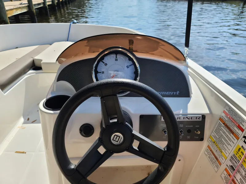 Slide: The Image of 2019 Bayliner Element E16 boat with canopy in a marina setting. - 11