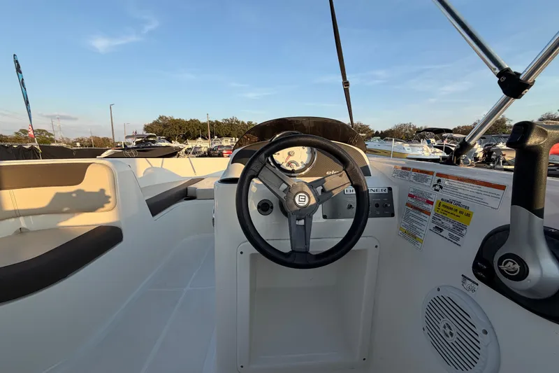 Slide: The Image of 2019 Bayliner Element E16 boat interior with steering wheel and seating area. - 18
