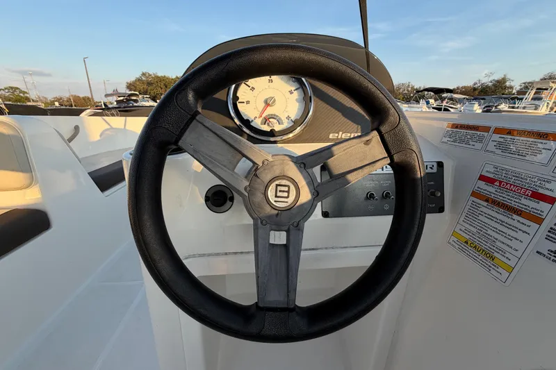 Slide: The Image of 2019 Bayliner Element E16 steering wheel and dashboard with warning labels. - 19