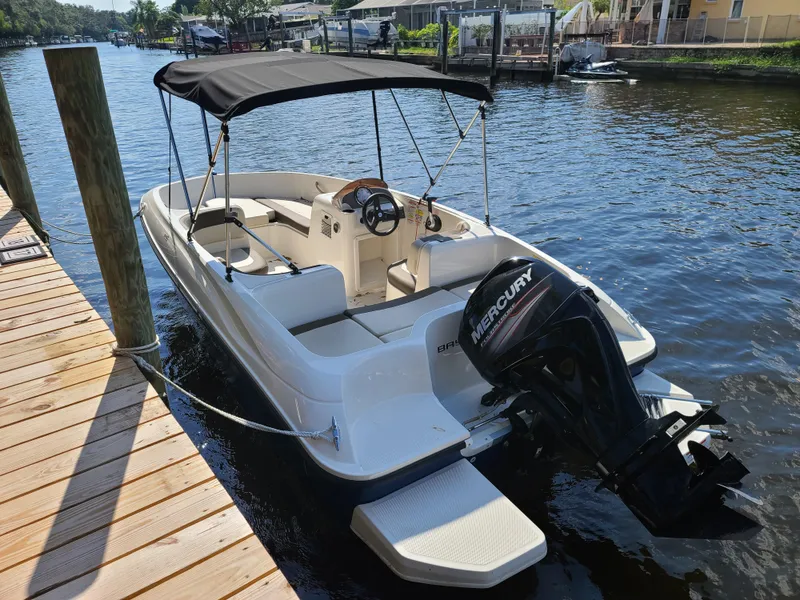 Slide: The Image of 2019 Bayliner Element E16 boat with Mercury engine on trailer, parked outdoors. - 2
