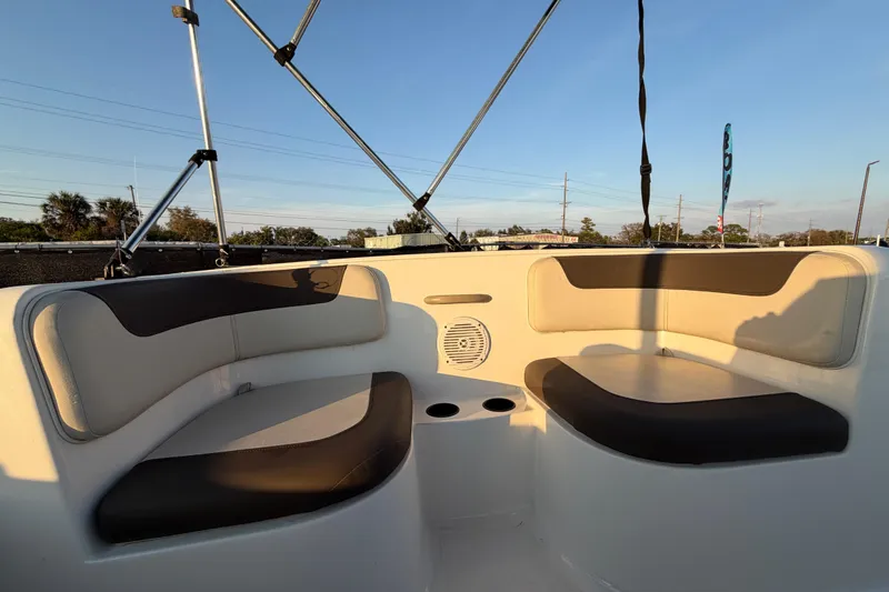 Slide: The Image of 2019 Bayliner Element E16 boat interior with cushioned seating and cup holders. - 26