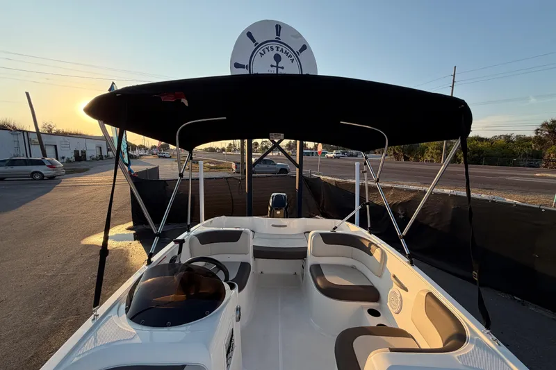 Slide: The Image of 2019 Bayliner Element E16 boat with canopy, parked at sunset. - 41