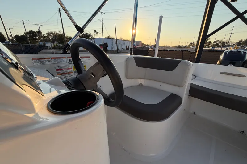 Slide: The Image of 2019 Bayliner Element E16 boat interior with steering wheel at sunset. - 46