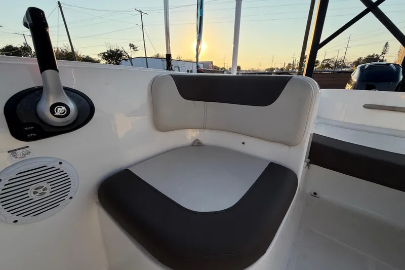 Slide: The Image of 2019 Bayliner Element E16 boat interior with seating and control panel at sunset. - 47