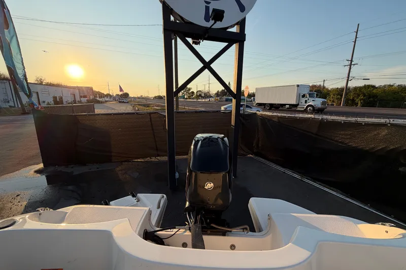 Slide: The Image of 2019 Bayliner Element E16 boat with outboard motor at sunset, parked near a road. - 52