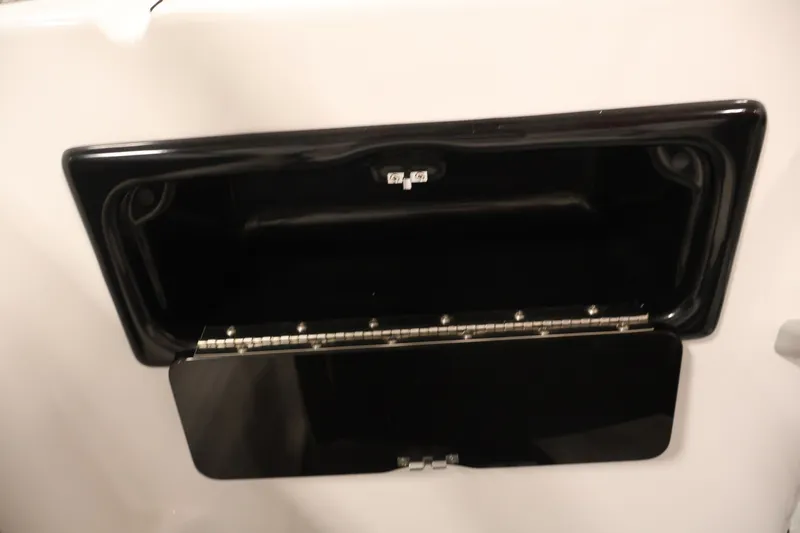 Slide: The Image of 2026 Yamaha Boats SX195 storage compartment with open black hatch. - 37