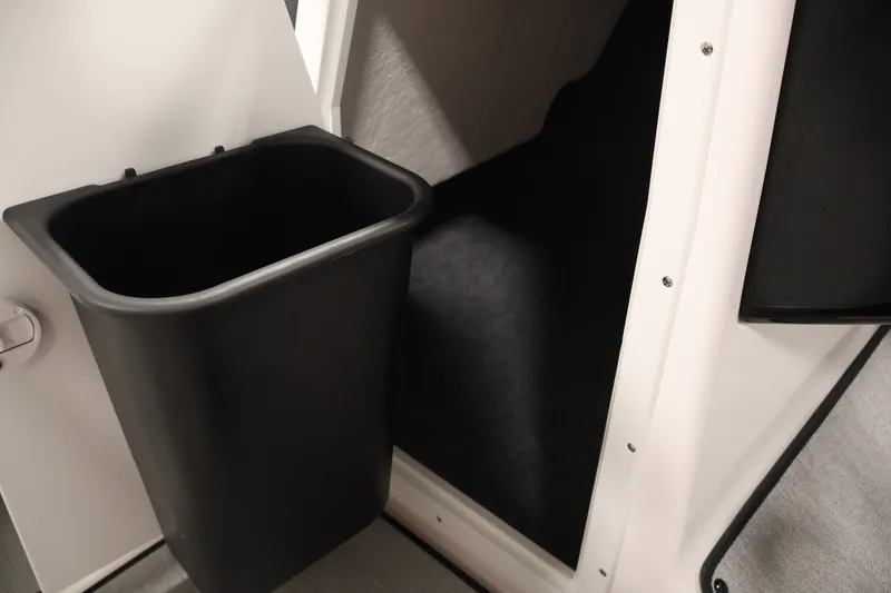Slide: The Image of Interior storage compartment of 2026 Yamaha Boats SX195 with black bin. - 34