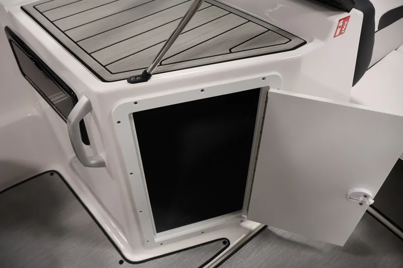 Slide: The Image of 2026 Yamaha Boats SX195 storage compartment with open door, showcasing sleek interior design. - 36