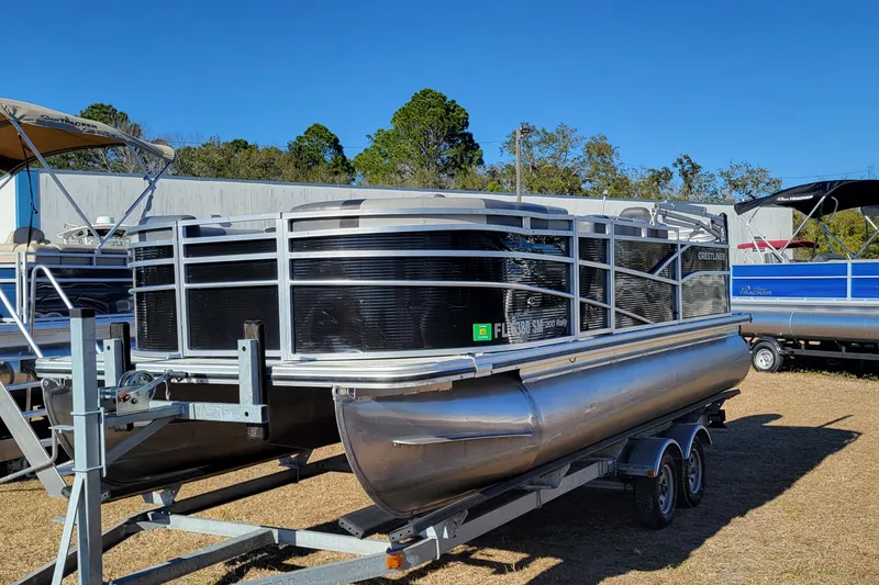 Slide: The Image of 2020 Crestliner 200 Rally DX CS pontoon boat on trailer, parked outdoors. - 2