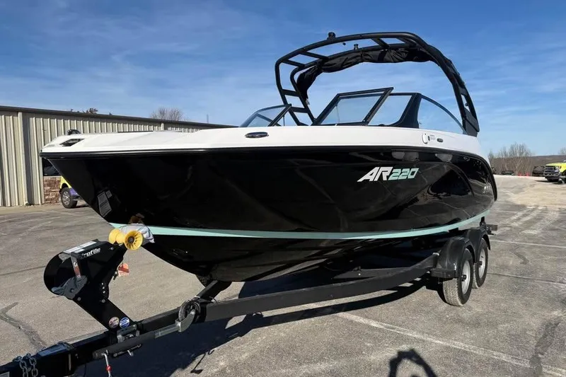 Slide: The Image of 2026 Yamaha Boats AR220 on trailer, sleek black and white design, parked outdoors. - 1