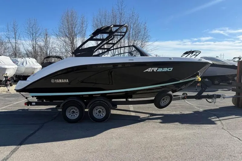 Slide: The Image of 2026 Yamaha Boats AR220 on trailer, sleek black and white design, parked outdoors. - 3