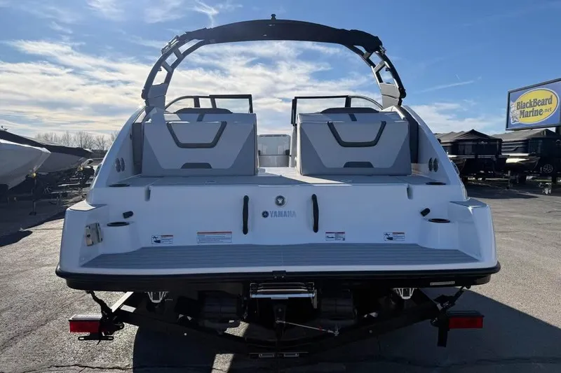 Slide: The Image of 2026 Yamaha Boats AR220, rear view, parked outdoors at BlackBeard Marine dealership. - 5