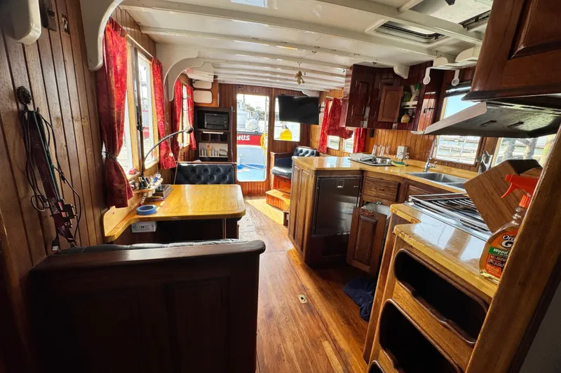Slide: The Image of Interior of a 1918 Peterson Tugboat with wooden furnishings and red curtains. - 17