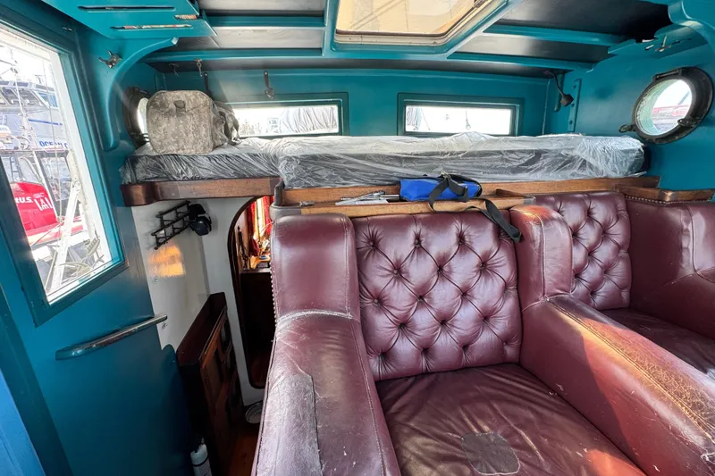 Slide: The Image of Interior of a 1918 Peterson Tug with vintage leather seating and nautical decor. - 20