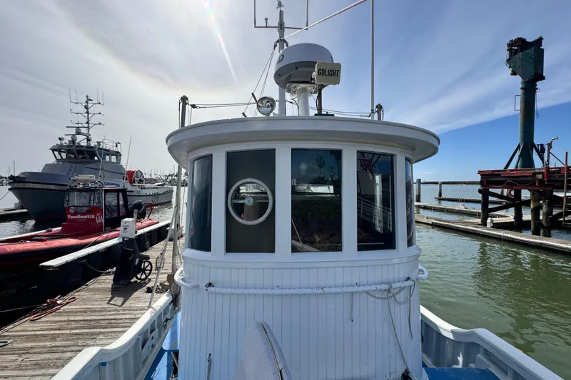 Slide: The Image of Historic 1918 Peterson Tugboat docked at a marina, showcasing vintage maritime design. - 23