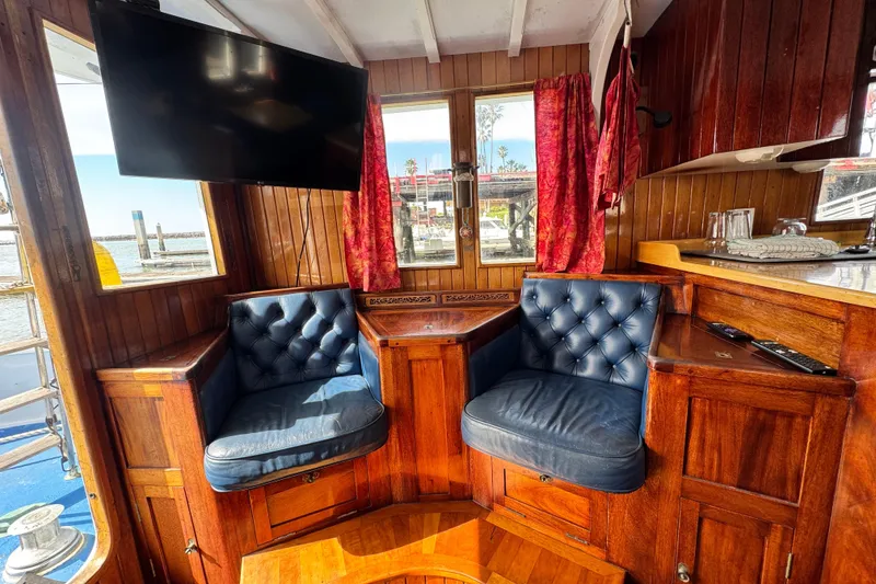 Slide: The Image of Interior of 1918 Peterson Tugboat with blue leather chairs and wooden paneling. - 4