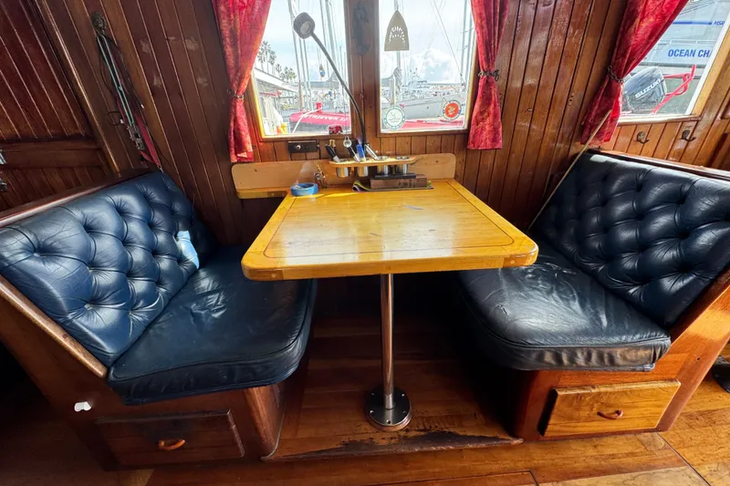 Slide: The Image of Cozy wooden interior of a 1918 Peterson Tug with leather seating and a central table. - 6