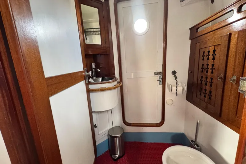 Slide: The Image of Vintage 1918 Peterson Tug bathroom with wooden accents and nautical decor. - 8