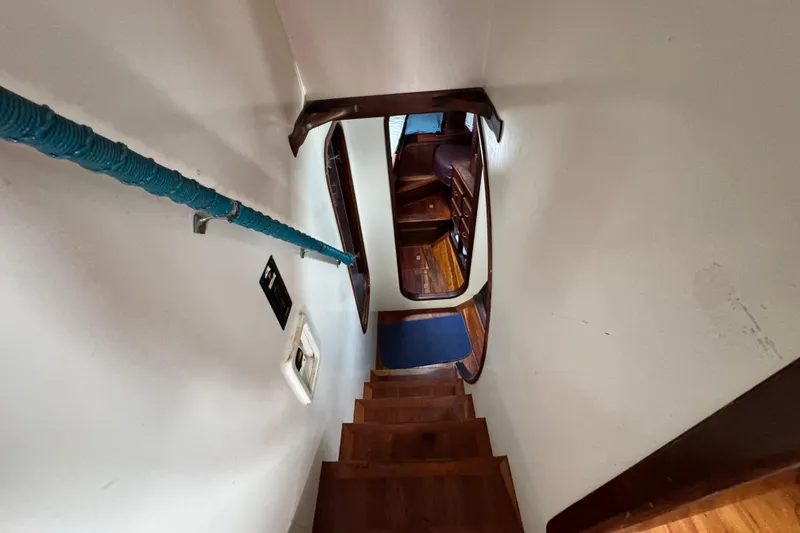 Slide: The Image of Staircase inside 1918 Peterson Tug, featuring wooden steps and a blue handrail. - 9