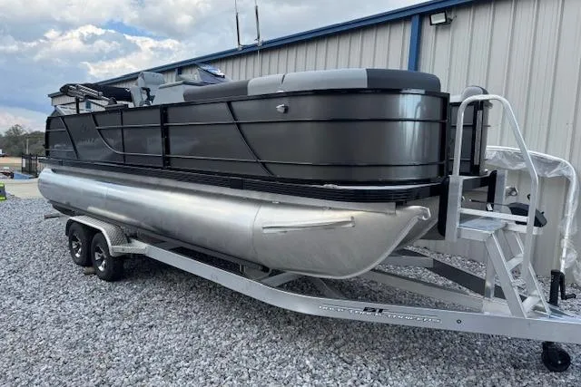 The Image of 2026 Veranda Relax VR22VLC pontoon boat on trailer, parked on gravel. - 1