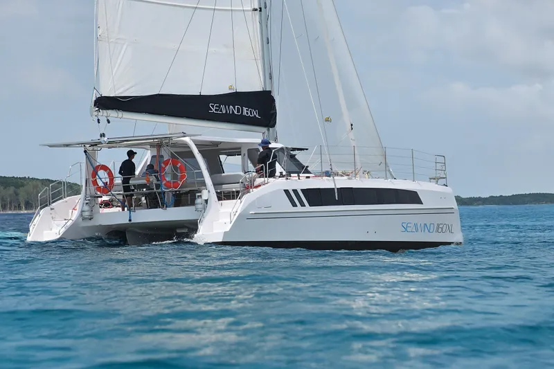 Slide: The Image of 2026 Seawind 1160XL catamaran sailing on clear blue water, featuring modern design and spacious deck. - 5