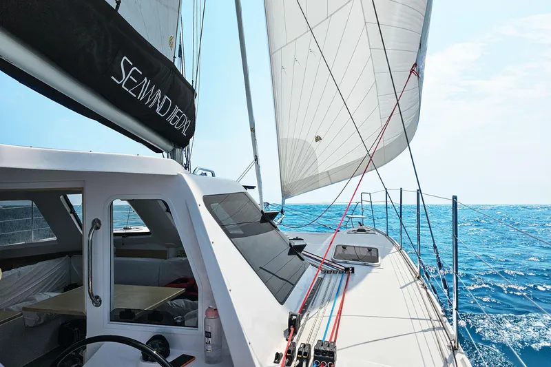Slide: The Image of 2026 Seawind 1160XL sailing on open ocean under clear blue sky. - 8