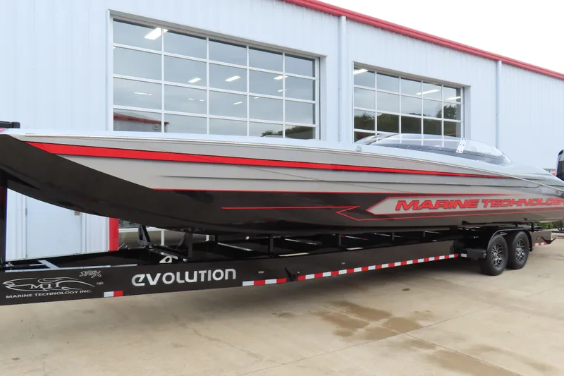 The Image of 2025 MTI 390X powerboat on trailer outside a modern building. - 1