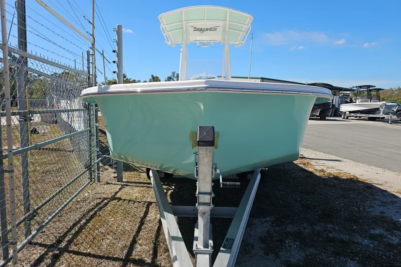 Slide: The Image of 2025 Savannah SS21 boat on trailer, parked outdoors under clear blue sky. - 8
