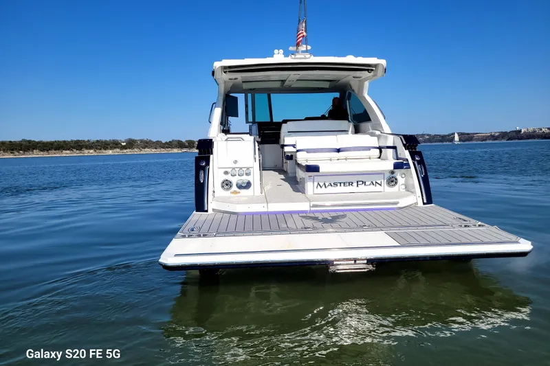 Slide: The Image of 2023 Formula 380 Super Sport Crossover I/O boat on calm water, rear view. - 13
