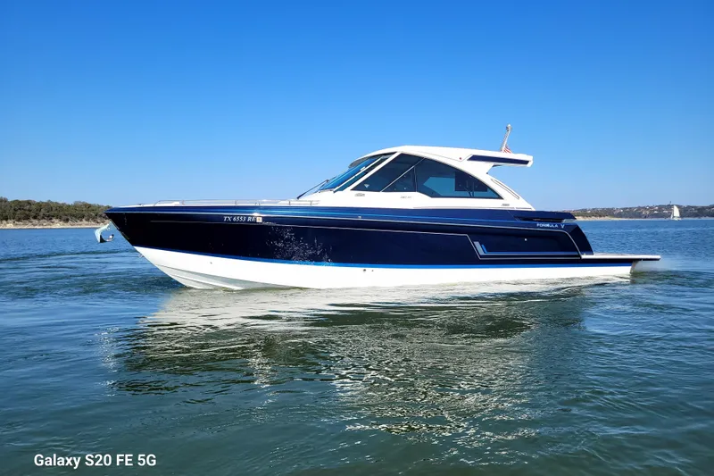 Slide: The Image of 2023 Formula 380 Super Sport Crossover I/O boat docked in covered marina. - 17