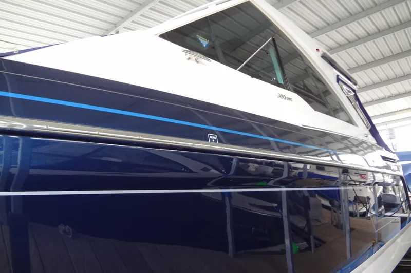 Slide: The Image of 2023 Formula 380 Super Sport Crossover I/O boat in a covered marina. - 18