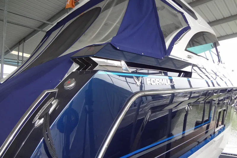 Slide: The Image of 2023 Formula 380 Super Sport Crossover I/O yacht in marina, sleek blue design. - 21