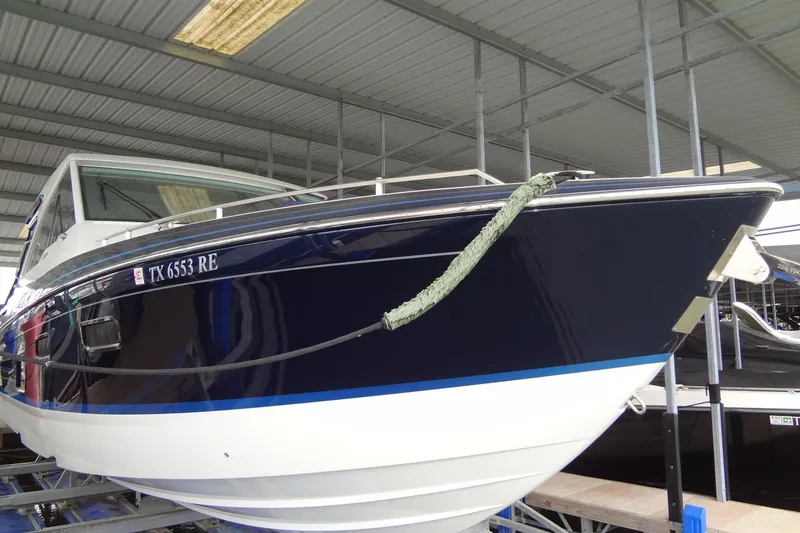 Slide: The Image of 2023 Formula 380 Super Sport Crossover I/O boat docked in covered marina. - 22