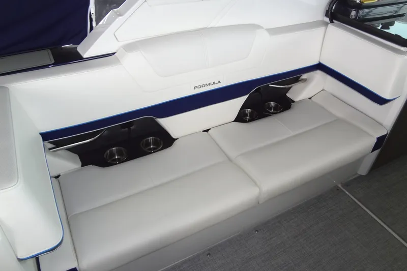 Slide: The Image of 2023 Formula 380 Super Sport Crossover I/O boat interior with white seating and cup holders. - 28